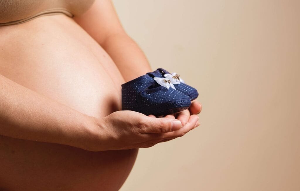 pregnant woman holding a shoe